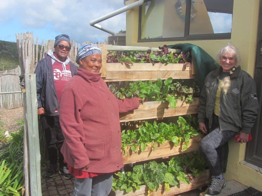 Karel, Bavie and Anthea with food grown through the Back 2 Front Yard Farming initiative