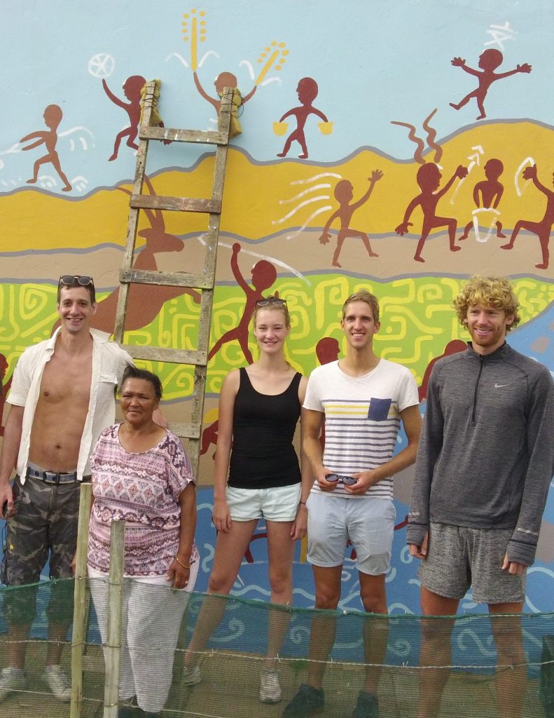 Miena proudly shows off the final mural with Bruce and volunteers Nikki, Frank & Evert