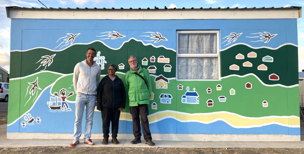 Caroline proudly stands beside her new mural, joined by its designer Bruce, and Hans, Chairperson of Dreamcatcher South Africa